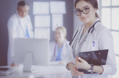 Kadın doktor hastanede steteskopla dikiliyor.