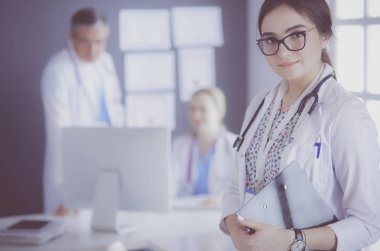 Kadın doktor hastanede steteskopla dikiliyor.