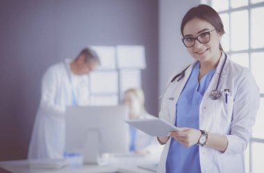 Hastane lobisinde tablet bilgisayar kullanan kadın doktor.