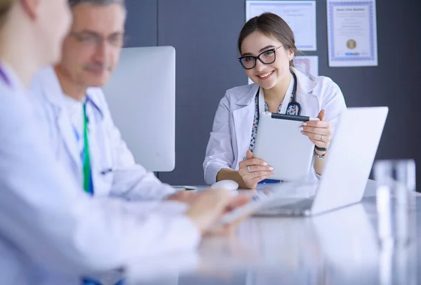 Equipe médica séria usando um laptop em um escritório brilhante — Fotografia de Stock