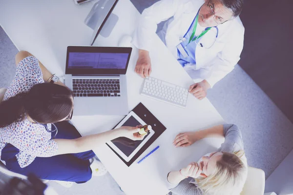 Médico e paciente discutindo algo enquanto se senta na mesa. Conceito de medicina e cuidados de saúde — Fotografia de Stock