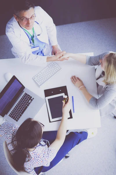 Médico e paciente discutindo algo enquanto se senta na mesa. Conceito de medicina e cuidados de saúde — Fotografia de Stock