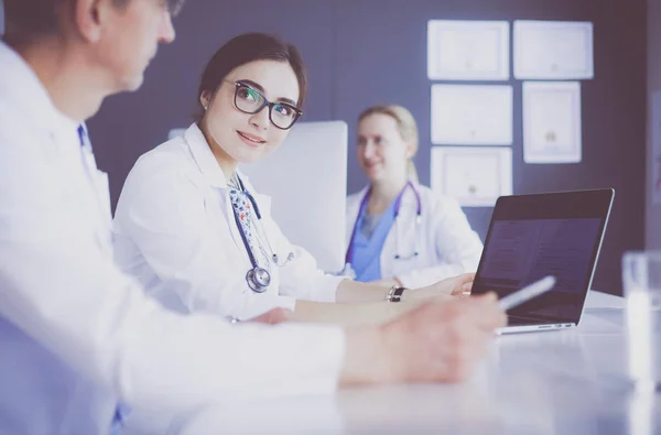 Serious medical team using a laptop in a bright office — Stock Photo, Image