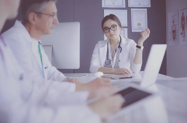 Serious medical team using a laptop in a bright office — Stock Photo, Image