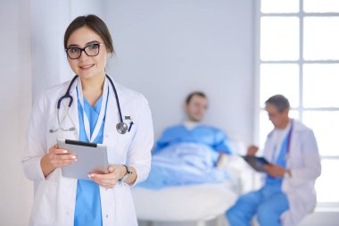 Hastane lobisinde tablet bilgisayar kullanan kadın doktor.