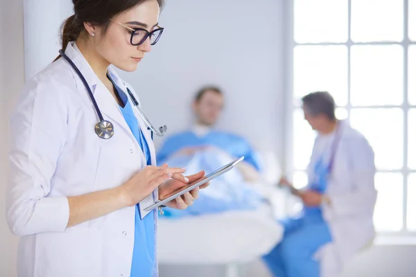 Female doctor using tablet computer in hospital lobby