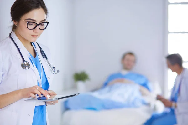 Female doctor using tablet computer in hospital lobby