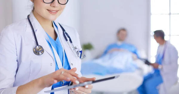 Female doctor using tablet computer in hospital lobby