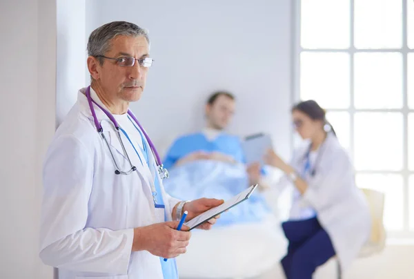 Médico segurando pasta na frente de um paciente e um médico — Fotografia de Stock