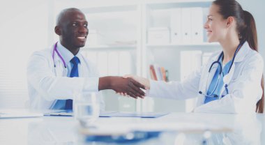 Ofiste tokalaşırken gülümseyen iki genç doktor.
