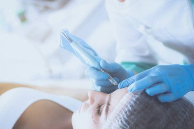 Kaşlar için kalıcı makyaj. Güzellik salonunda kalın kaşlı güzel bir kadın.