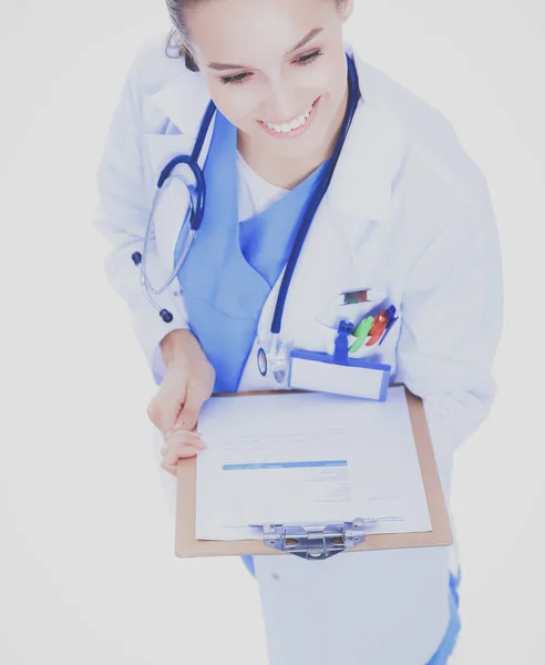 Jovem médica com área de transferência em pé sobre fundo branco — Fotografia de Stock