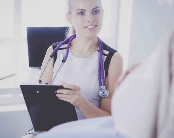 Jeune femme médecin avec stéthoscope et tablette parlant avec une femme enceinte à l'hôpital. — Photo