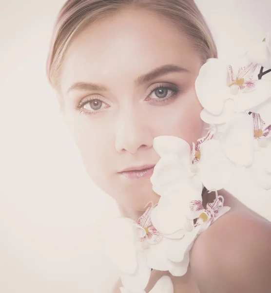Jovem mulher de beleza com flor perto do rosto — Fotografia de Stock