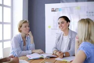 Masada kitaplarla çalışan gençler. Güzel kadınlar ve erkekler birlikte çalışıyor..