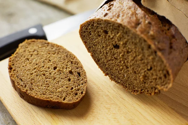 A loaf of Bread packed in paper on wooden table.