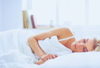 Güzel bir kadın yatağında uzanıyor.