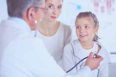 Steteskoplu kız ve doktor kalp atışlarını dinliyor.