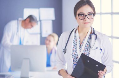 Kadın doktor hastanede steteskopla dikiliyor.