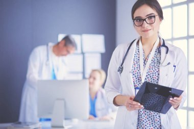 Hastane lobisinde tablet bilgisayar kullanan kadın doktor.