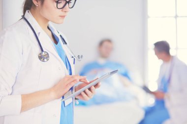 Hastane lobisinde tablet bilgisayar kullanan kadın doktor.