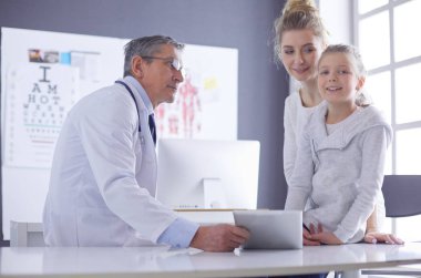 Küçük tatlı bir kız ve hastanedeki doktorunun portresi.