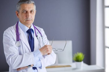 Parlak ofisinde gülümseyen bir doktorun portresi.