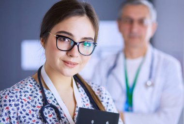 Bir doktor ekibi, kadın ve erkek, ofiste bekliyorlar.