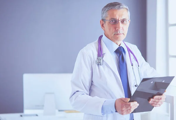 Ärztin schreibt Notizen auf Klemmbrett im Krankenhaus — Stockfoto