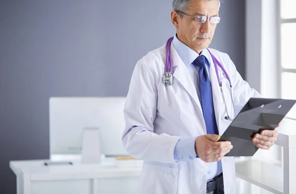 Ärztin schreibt Notizen auf Klemmbrett im Krankenhaus — Stockfoto