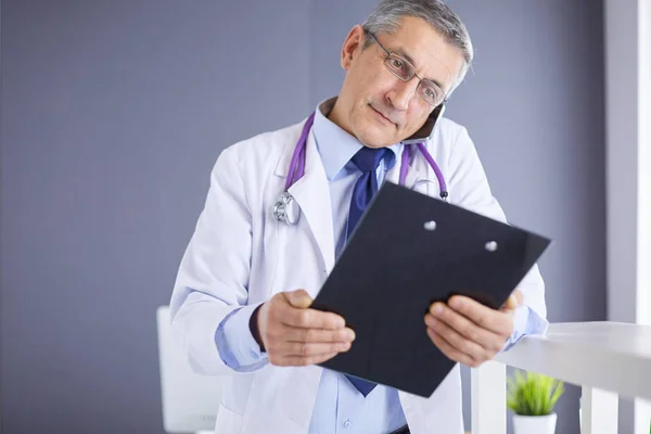 Мужчина-врач пишет заметки на планшете в больнице — стоковое фото
