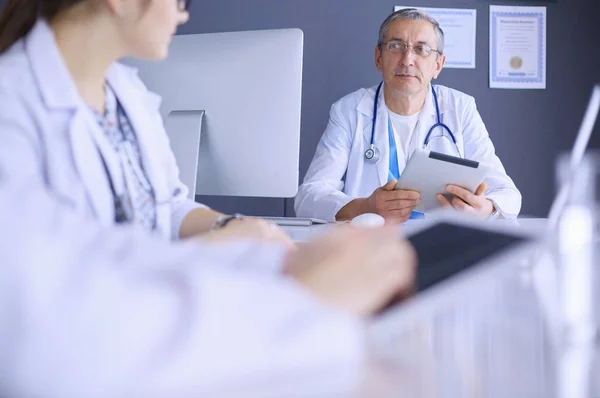 Serieuze medische team met behulp van een laptop in een helder kantoor — Stockfoto