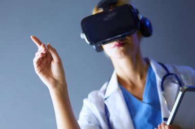 Sanal gerçeklik gözlüğü takan kadın doktor beyaz arka planda izole edilmiş..