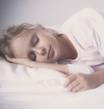 çocuk oyuncak oyuncak ayı ile yatakta uyur küçük kız.