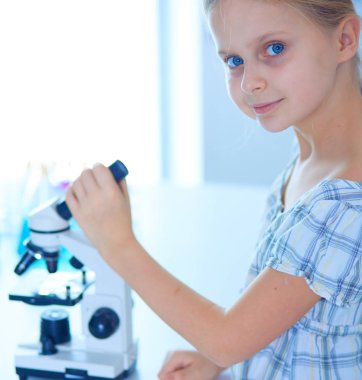 kız öğrenci fen bilgisi dersinde mikroskop aramak.