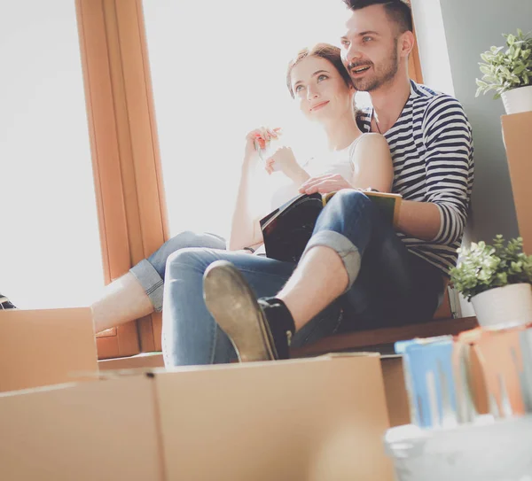 Par som flyttar i huset sitter på fönsterbrädan. Par — Stockfoto