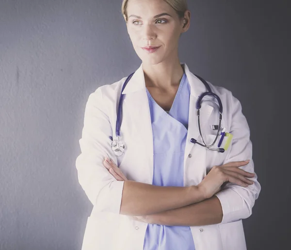 Retrato de una joven doctora con una bata blanca de pie en el hospital. — Foto de Stock