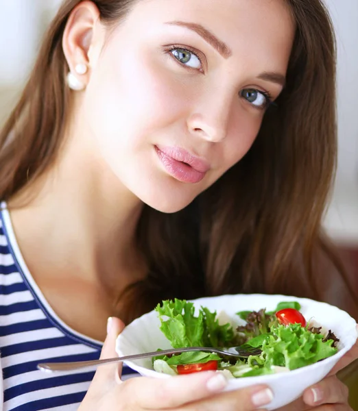 Ung kvinna äta sallad och hålla en blandad sallad. Ung kvinna — Stockfoto