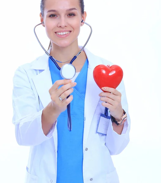 Médica feminina positiva em pé com estetoscópio e símbolo de coração vermelho isolado. Mulher médica — Fotografia de Stock