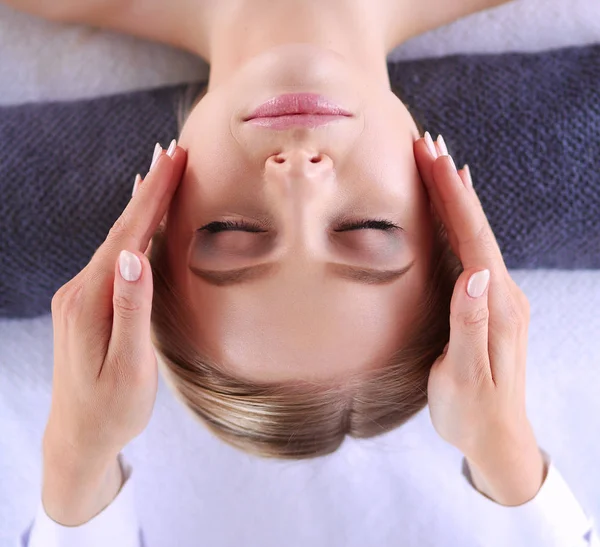 Mujer joven acostada en una mesa de masaje, relajándose con los ojos cerrados. Una mujer. Salón de spa — Foto de Stock