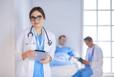 Hastane lobisinde tablet bilgisayar kullanan kadın doktor.