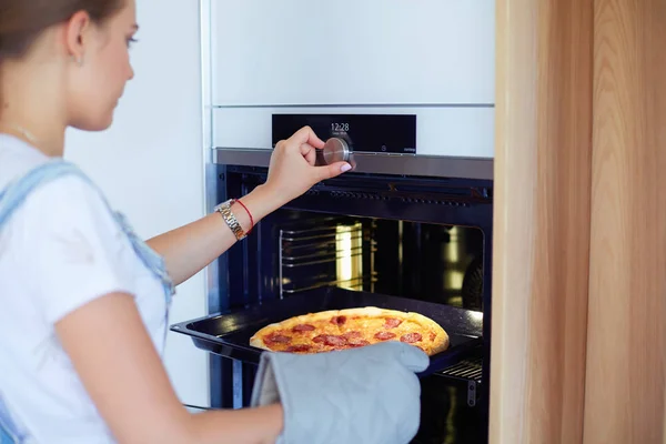 행복 한 젊은 여자 가 집에서 피자를 요리하는 모습 — 스톡 사진