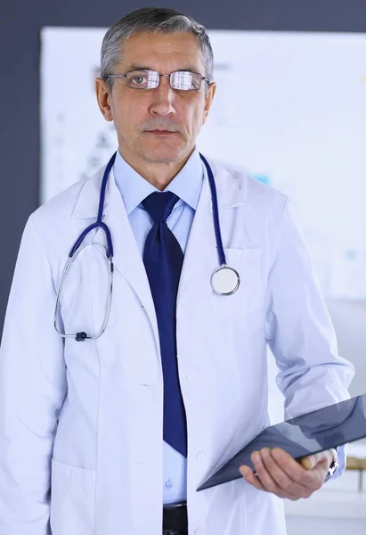 Man dokter schrijft notities op het klembord in het ziekenhuis — Stockfoto