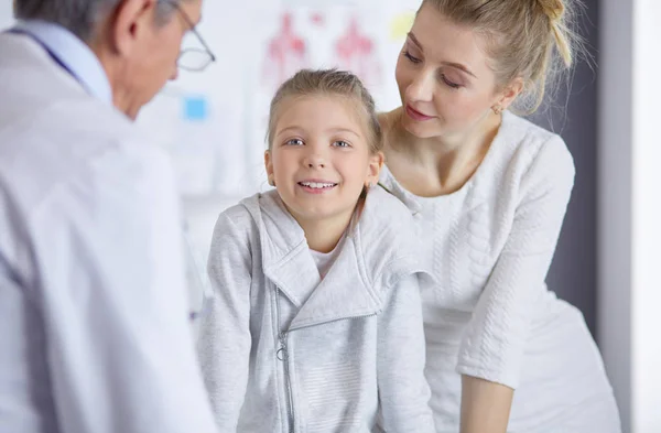 Klein meisje met haar moeder op consult bij een dokter — Stockfoto