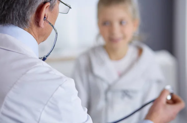 Menina e médico com estetoscópio ouvindo batimentos cardíacos — Fotografia de Stock