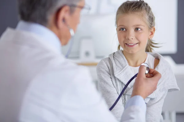 Chica y médico con estetoscopio escuchando los latidos del corazón —  Fotos de Stock