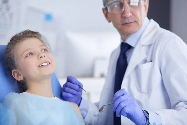 Niña sentada en el consultorio de dentistas — Foto de Stock