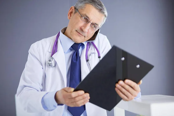 Male doctor writes notes on the clipboard in the hospital — Stock Photo, Image