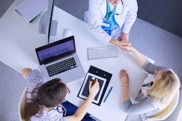 Doktorn och patienten diskuterar något när de sitter vid bordet. Medicin och hälsovård — Stockfoto