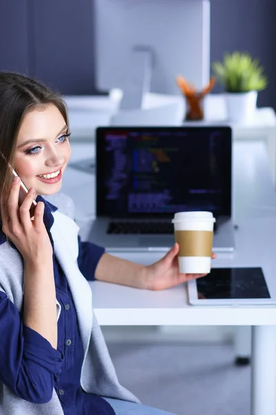 Jovem mulher feliz falando no telefone celular enquanto se senta com xícara de café — Fotografia de Stock